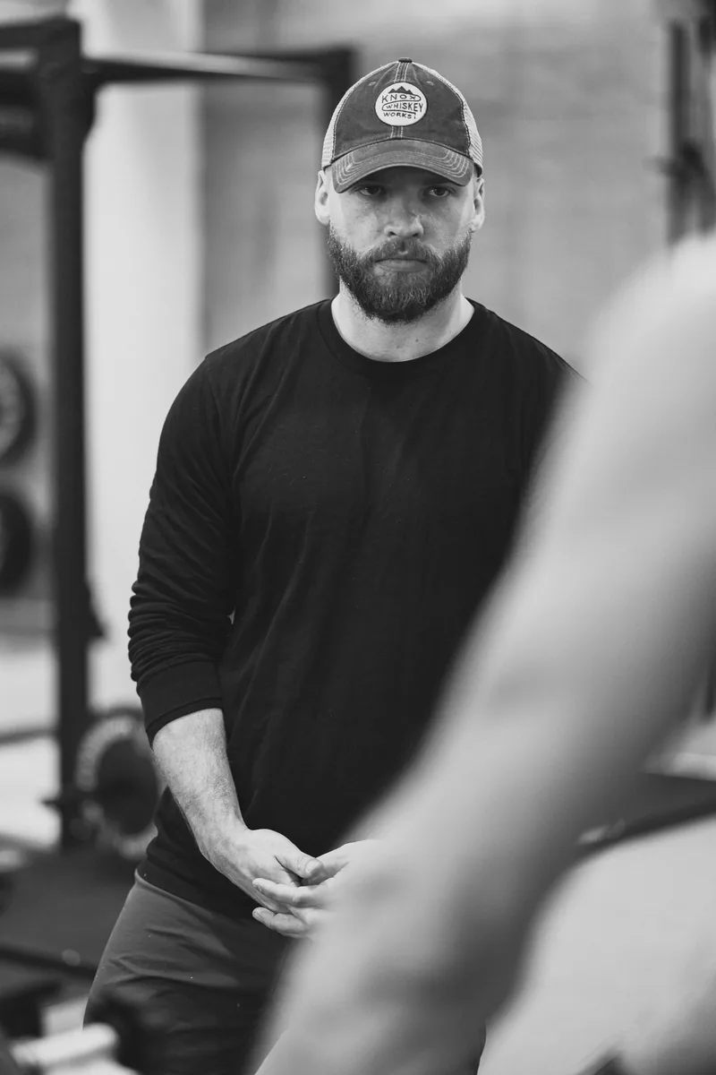 Sam Purchase on the gym floor, watching a client train